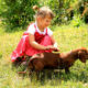 girl playing with dachshund